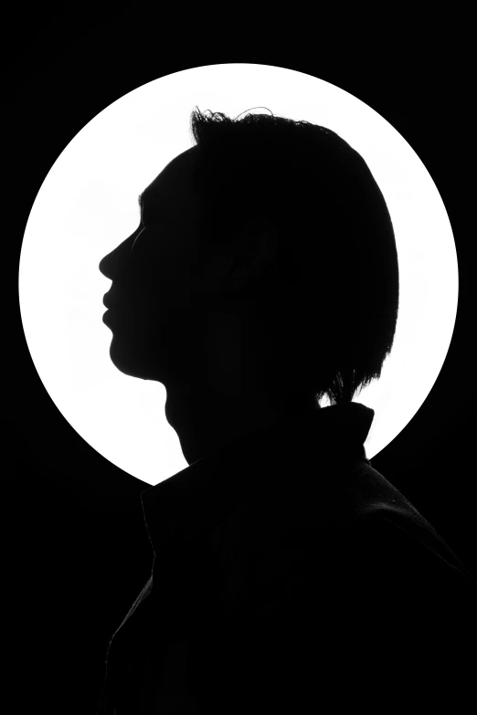 the silhouette of a man with a full moon in the background