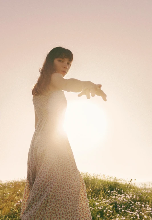 a woman standing on top of a field of flowers