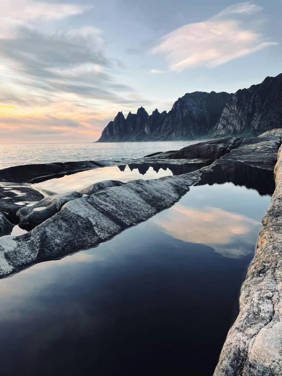 the sky is reflected in the water on the beach