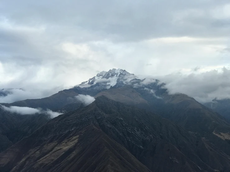 clouds loom over the mountains and surrounding a large mountain