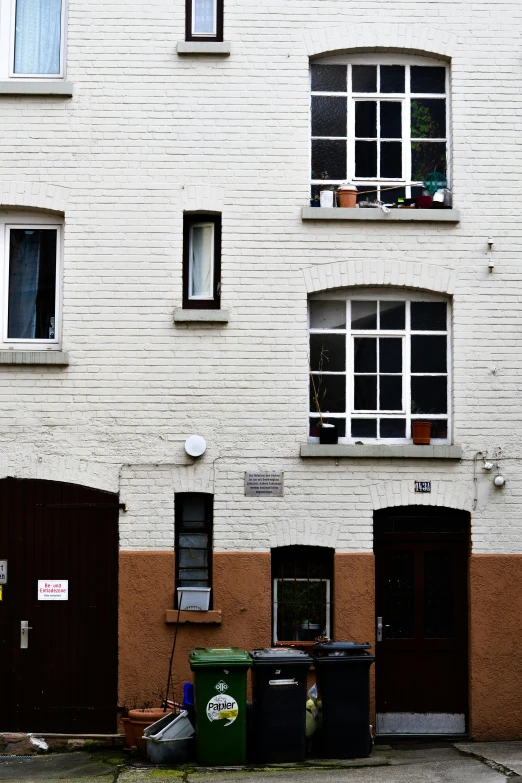 a white brick building with three different sets of windows