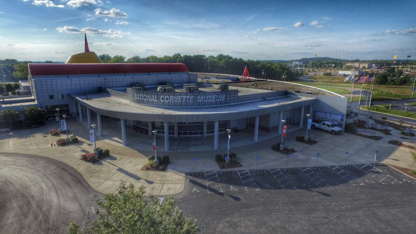 an aerial po of a parking lot with a building and cars