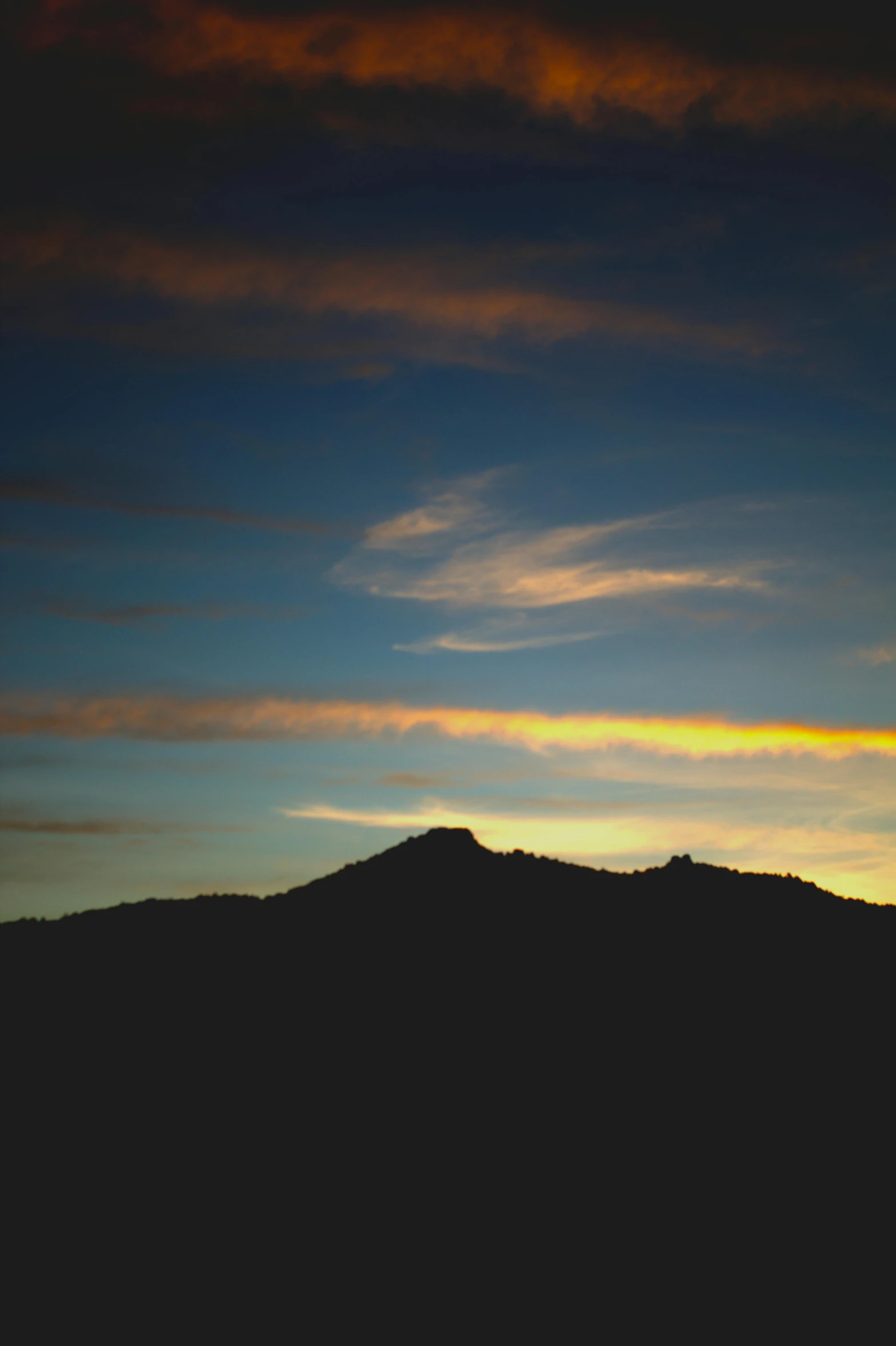 an airplane is flying over the mountains at sunset