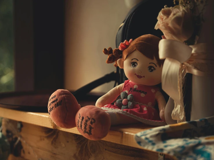 a small doll is sitting on a shelf next to an orange ball