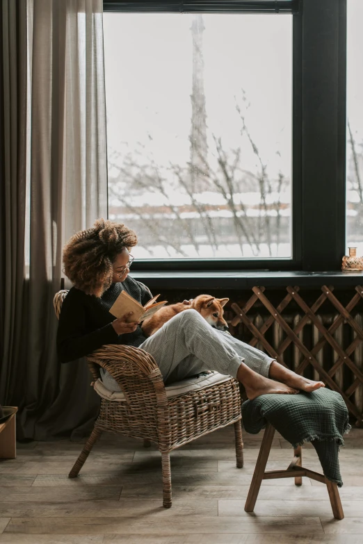 two women are sitting near a window looking out