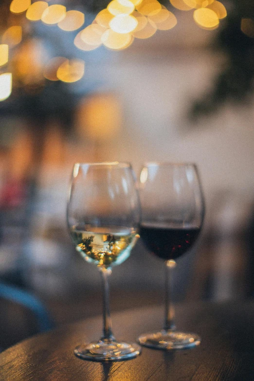 two glasses of wine sitting on top of a wooden table