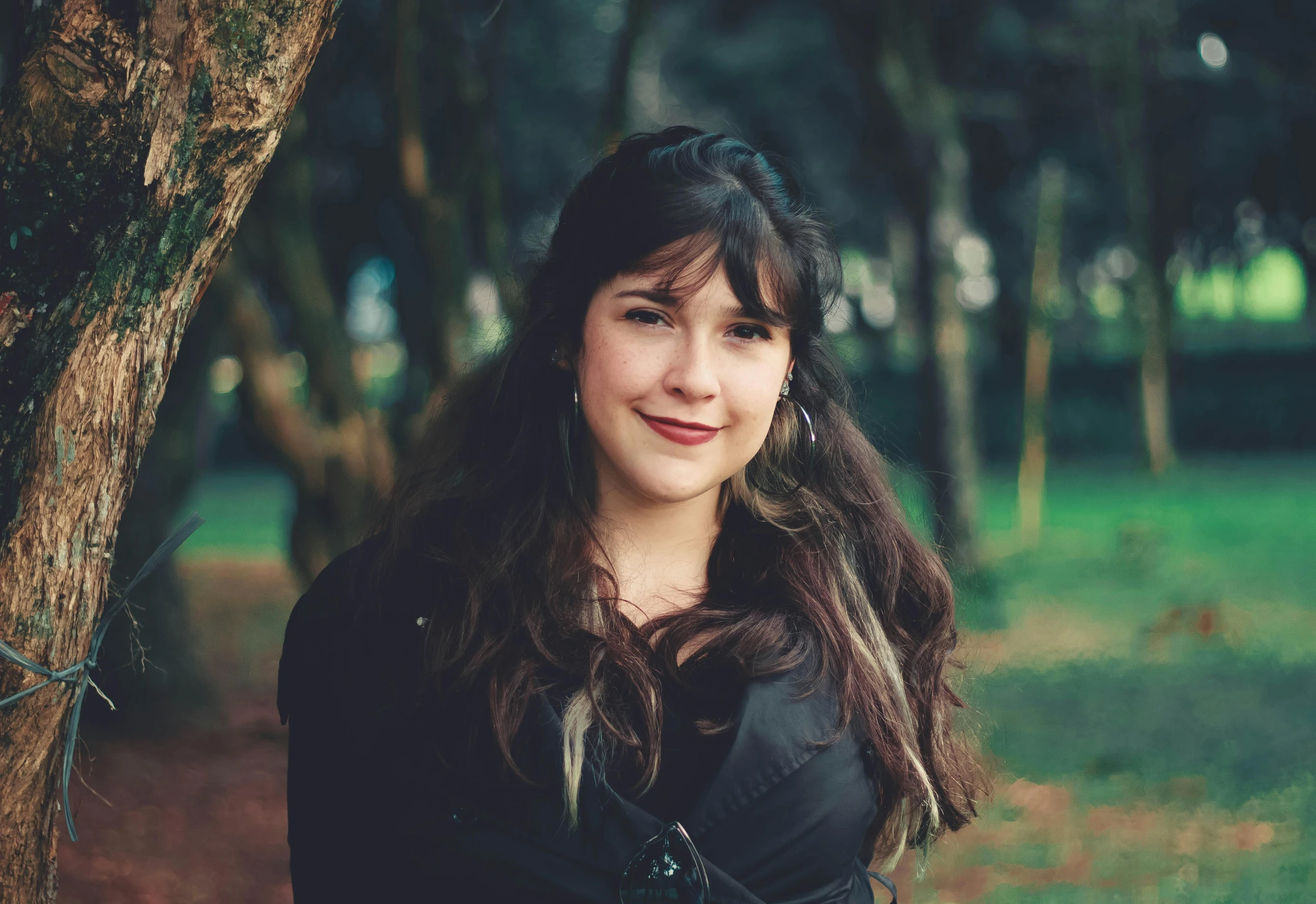 a girl with long hair is next to a tree