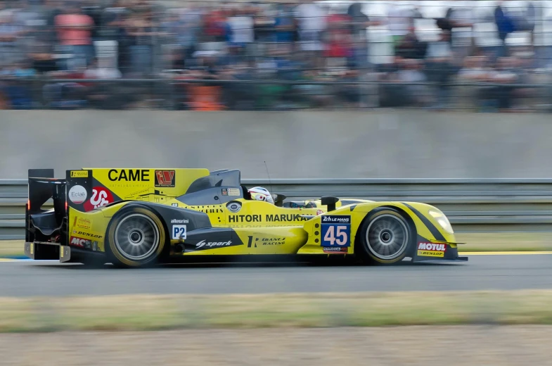 the yellow and black race car is speeding on the road