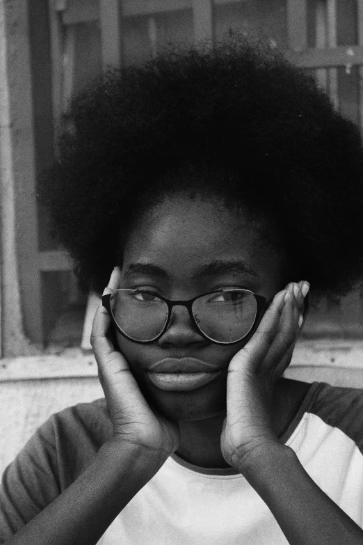 a woman holding her head and looking up with two hands near her face