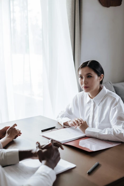 two women are sitting at the table working on a task