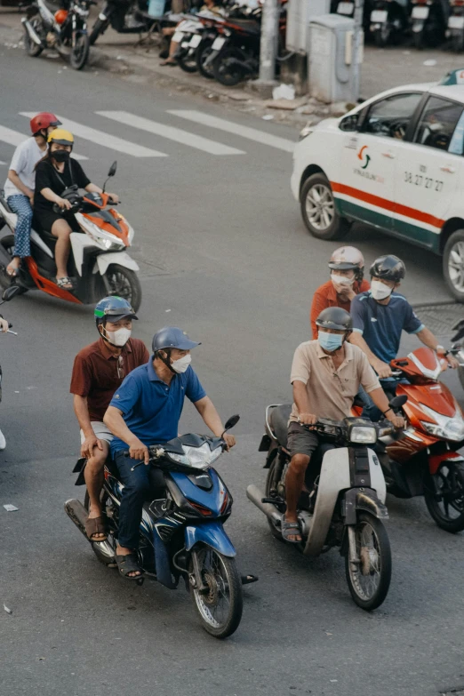 a group of people on motor cycles riding through the street