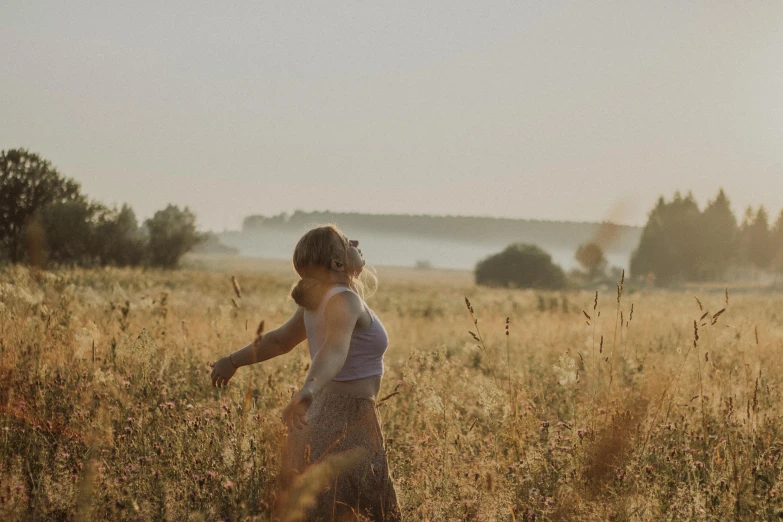 a woman in a field of tall brown grass