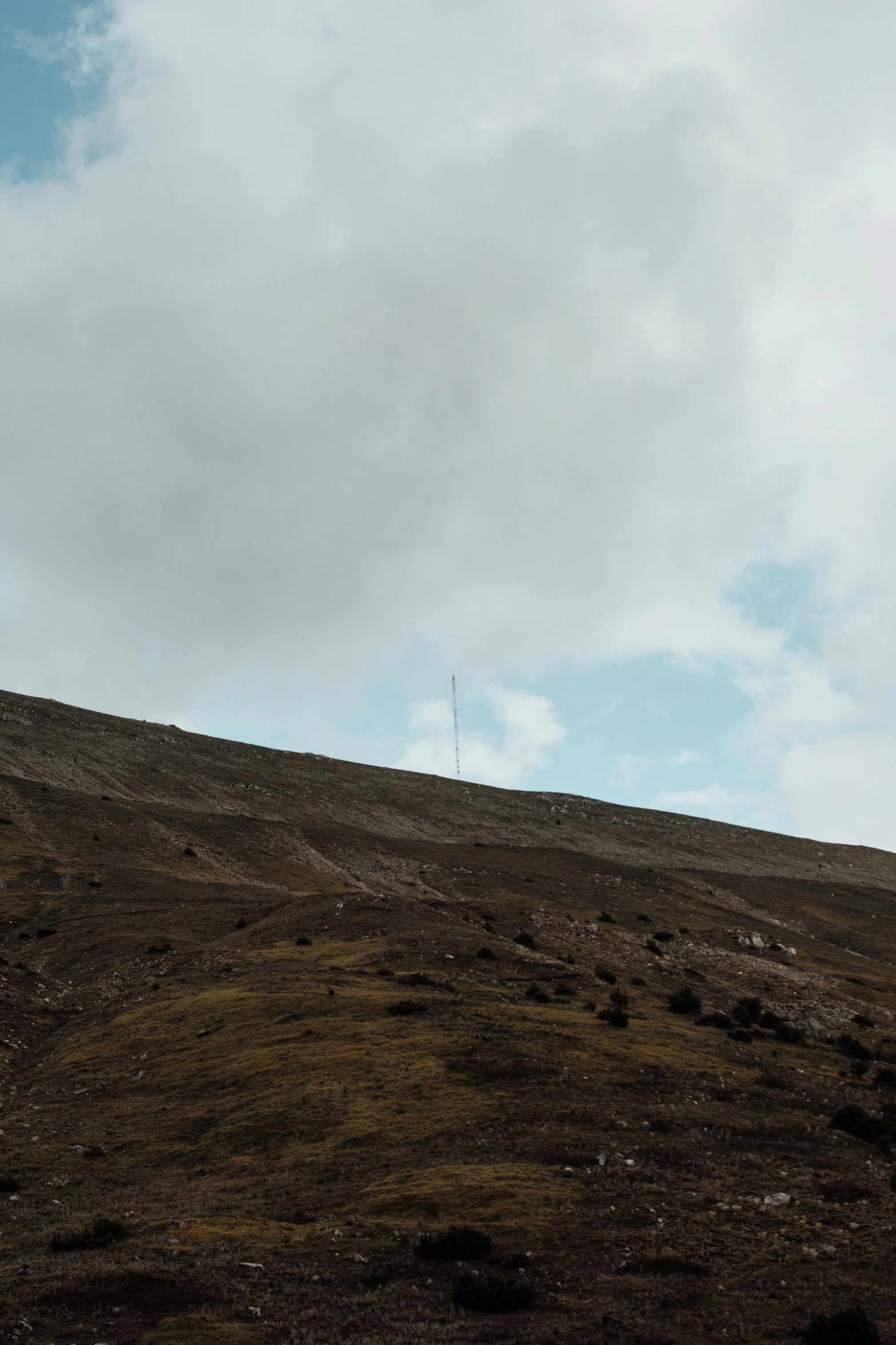 a small airplane is perched on top of a brown hill