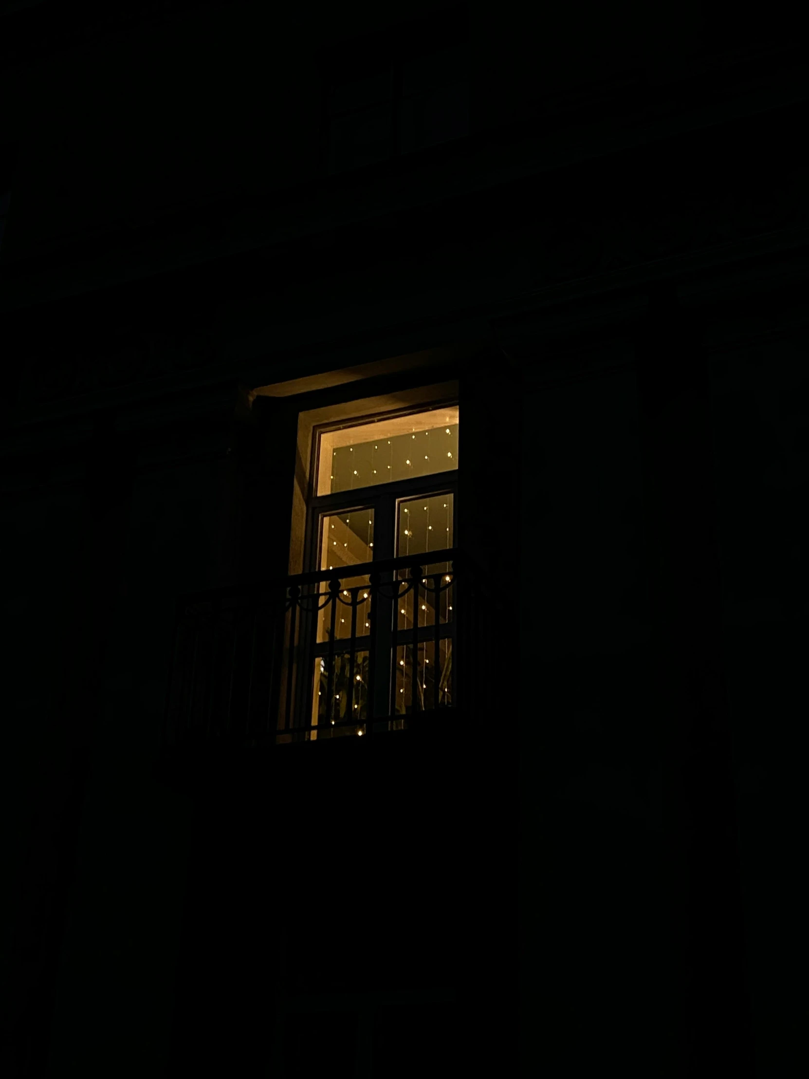 a silhouette of a light shines on a window with windowsill and balconies