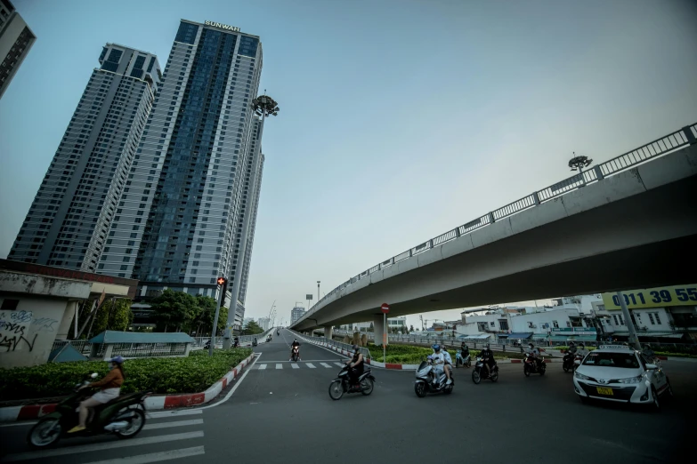 some vehicles are traveling down a busy street with high rise buildings in the background