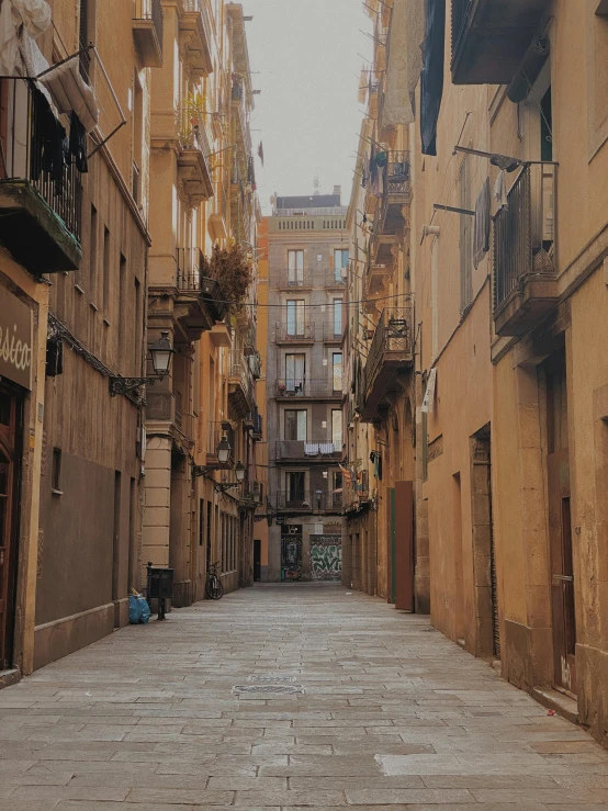 an alleyway between two building with balcony's