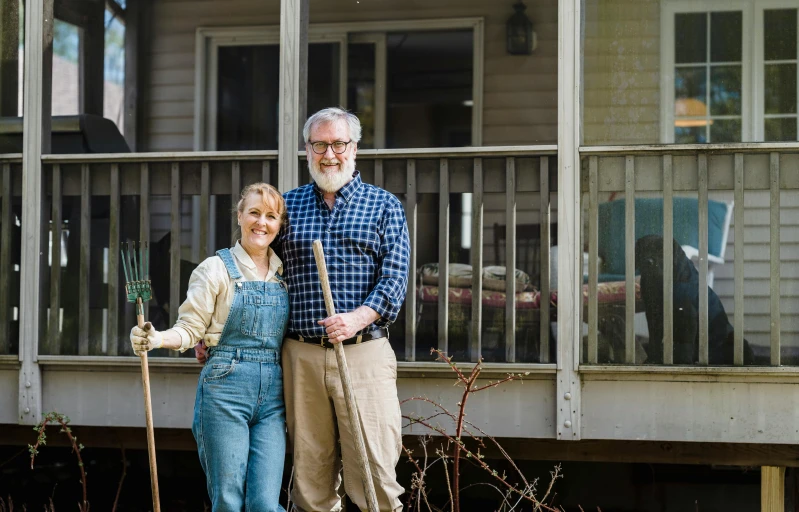 an older man and woman standing next to each other in front of a building