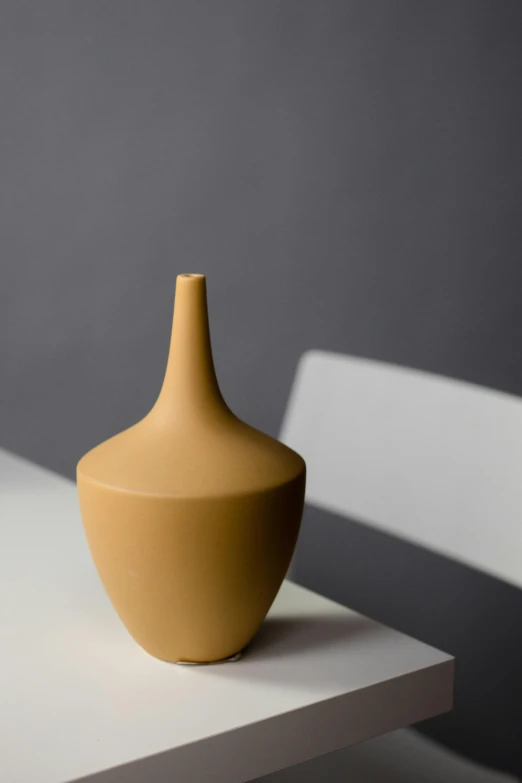 an empty vase sitting on top of a white bench