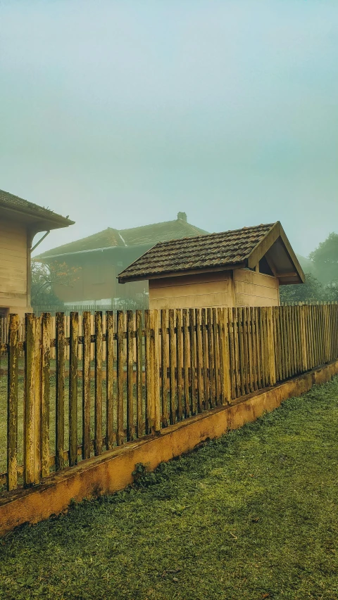 the fence is near the wooden cabins