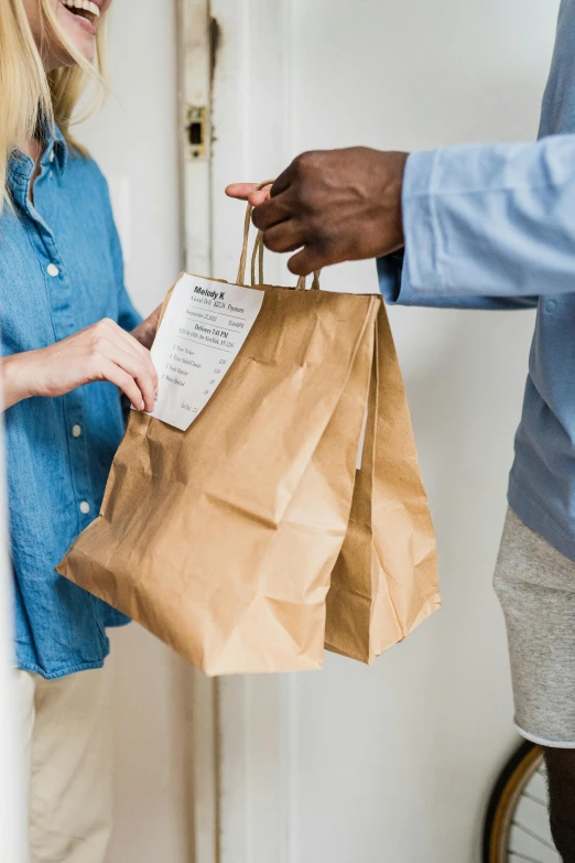 two people exchanging items from their purses to one another