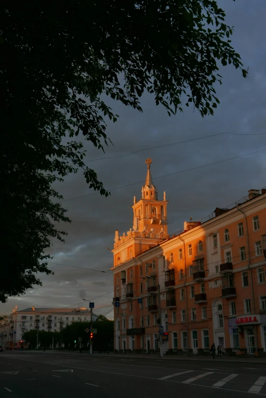 a large building with a clock tower and trees in front of it