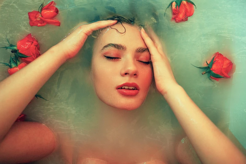 a woman taking a bath with red roses floating around her