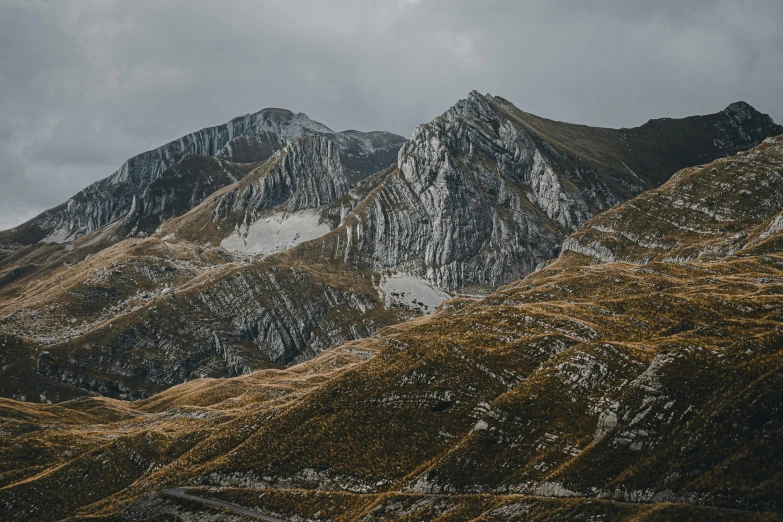 a group of mountains with some grass in the foreground