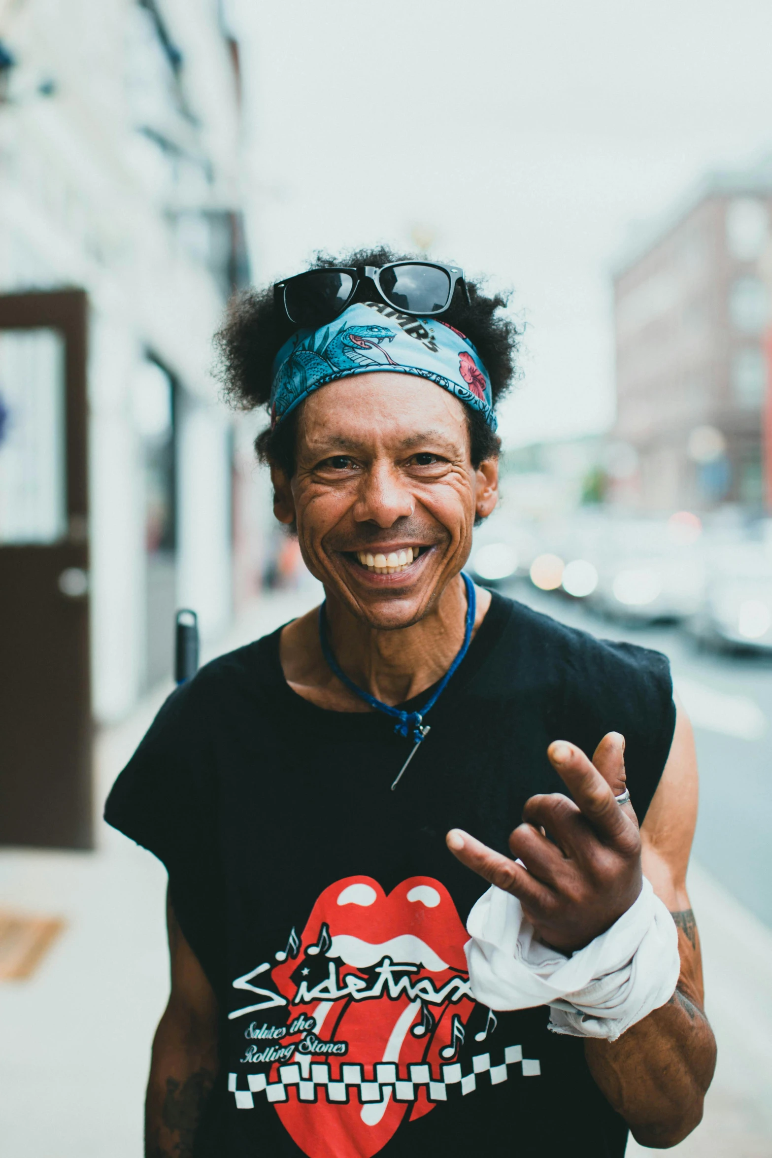 a man smiles at the camera on a city street