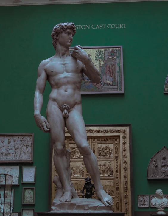 a large statue of a male in front of paintings