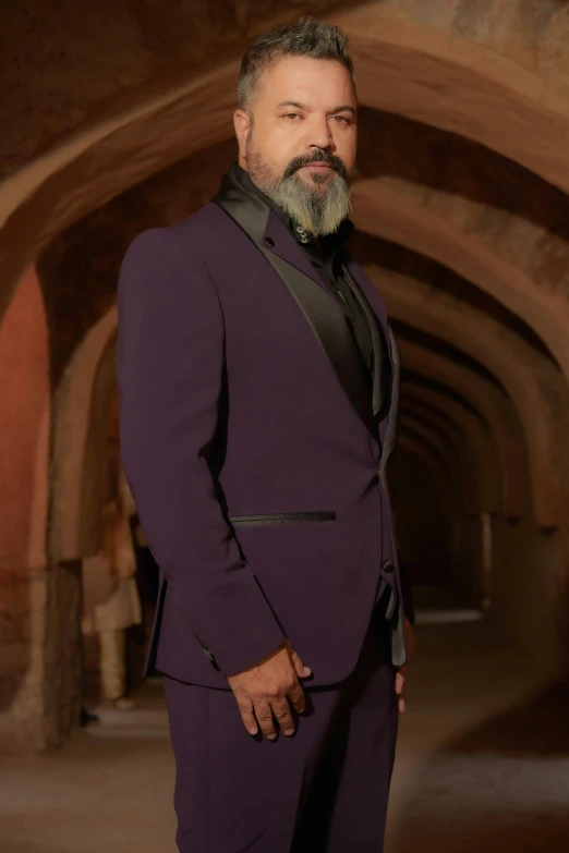 a man with a goatee and a beard in a purple suit