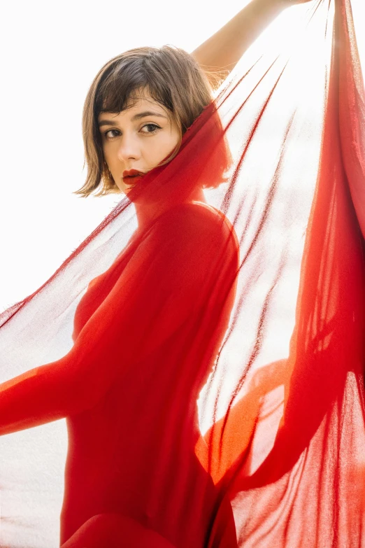 a woman posing in a red dress and an umbrella