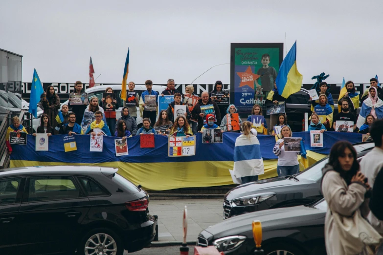 a crowd of people in street next to cars