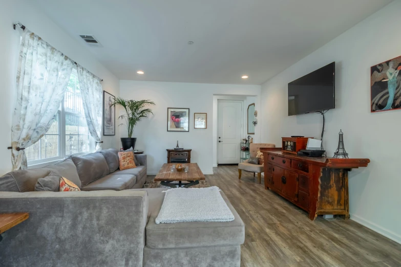 a living room with a couch, television and a wooden table