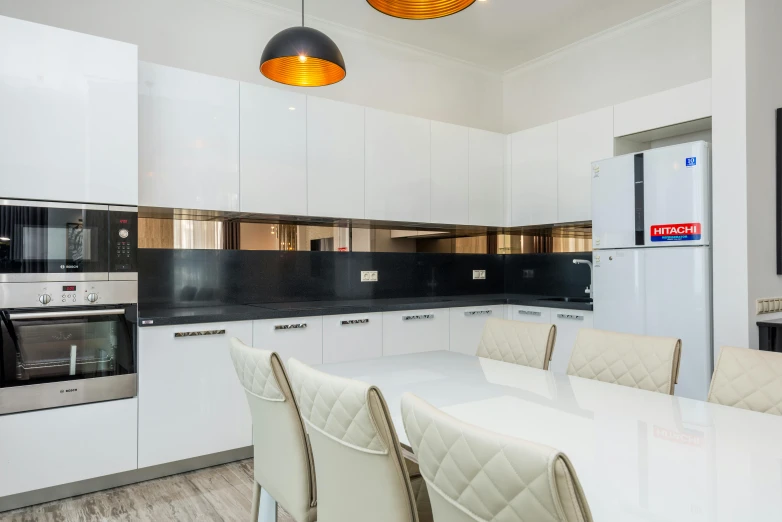 a kitchen with white cabinets and table chairs