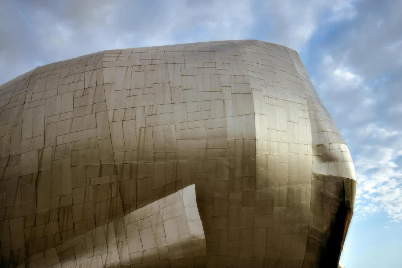 a big metal building sitting under a cloudy sky