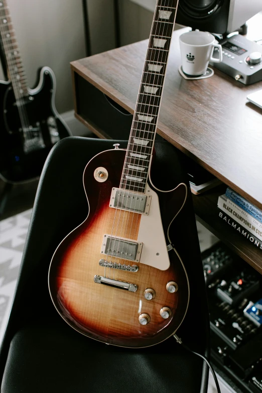 a guitar sitting on a chair with a remote control