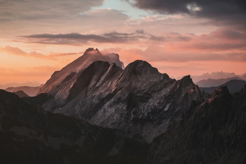 mountains are covered in fog and clouds during the day