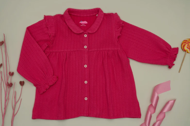 a small girl's red sweater and rose flowers