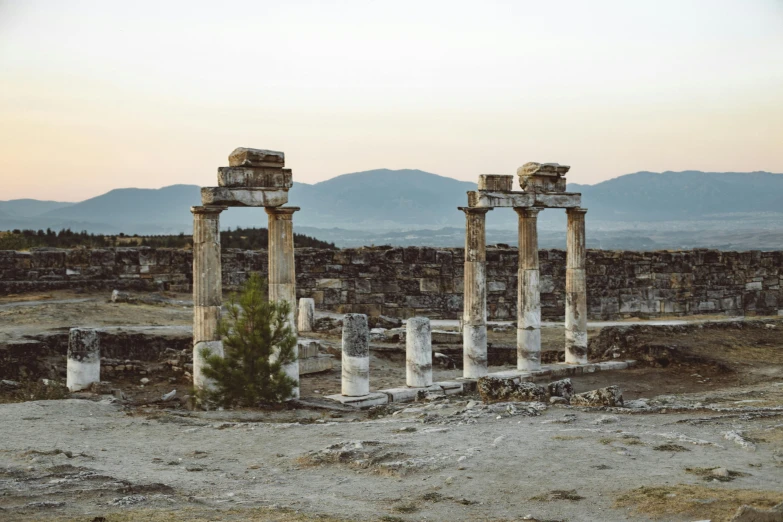 several old and stone ruins with mountains in the background