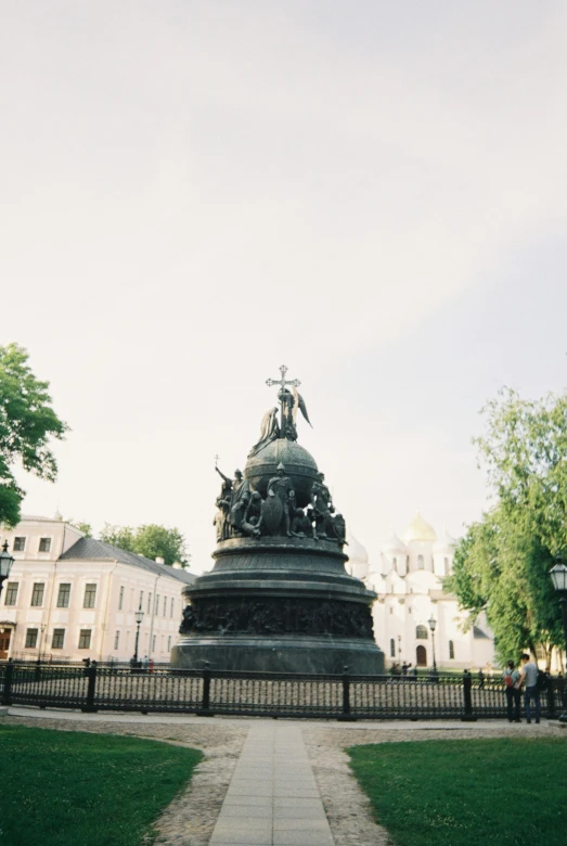 an old statue in the center of a park area