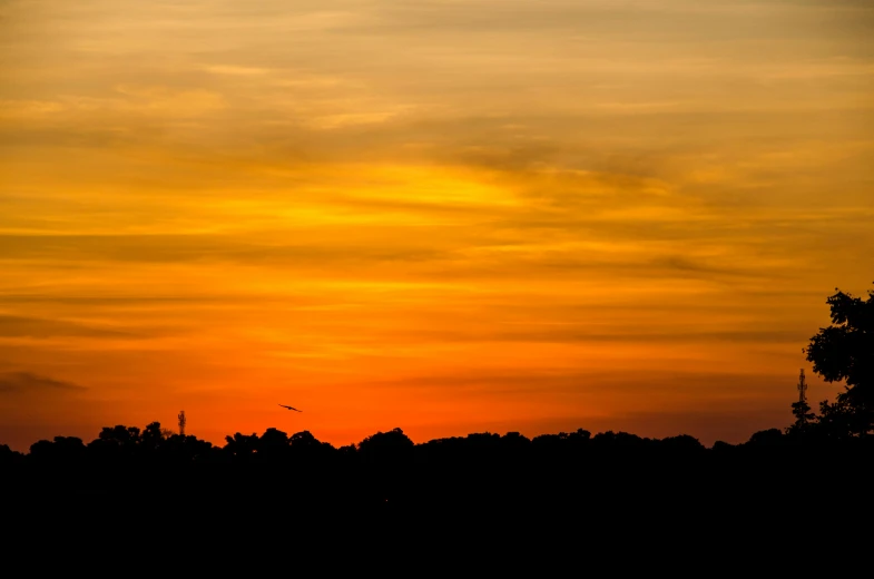 some large black and yellow sky with a plane flying in the distance