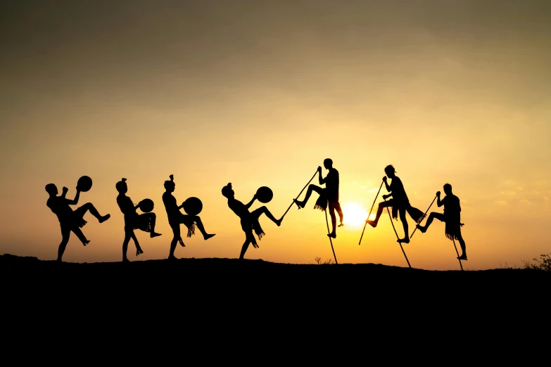 a group of people climbing up a mountain during the sunset