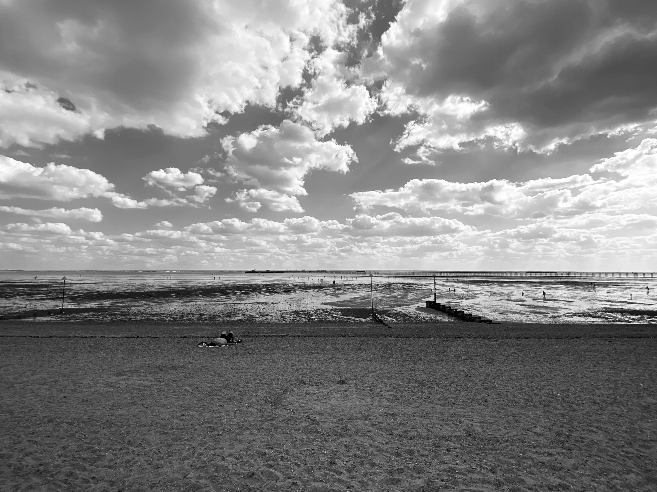 there is a person sitting on the beach alone