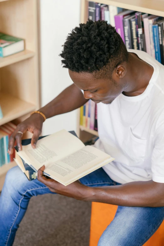 a black man reading a book in a liry