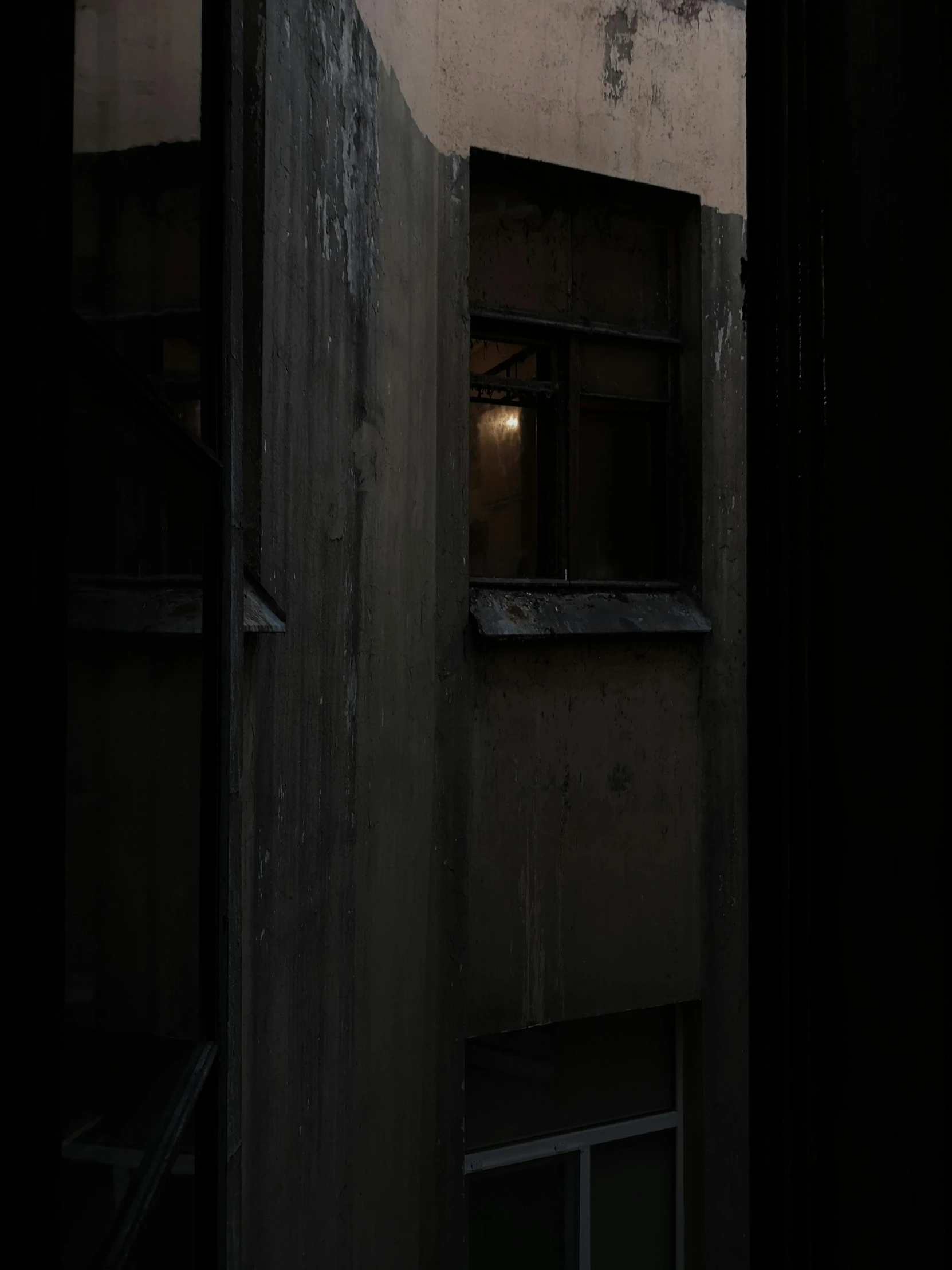 a doorway in a building at night, with a window in it