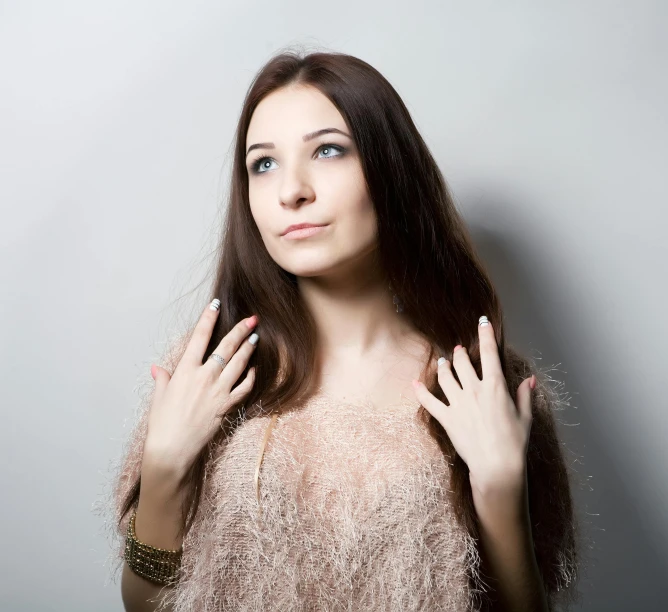 the beautiful woman with shiny nails poses for a po