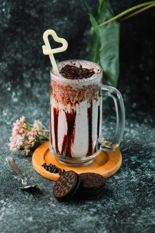 a cake in a glass mug on a plate with a tiny chocolate numeral