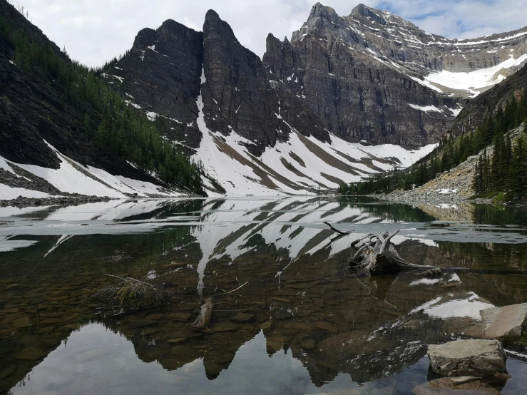 the mountains reflected in water with snow on them