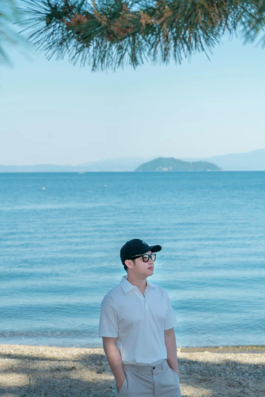 a man in sunglasses and a hat standing next to water