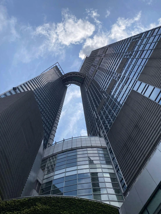 looking up at two tall office buildings from the ground